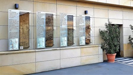 Bild von der Hausfassade mit vier Gesteinsprofilen und Infotafeln.
