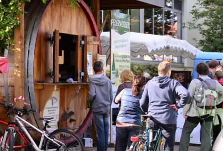 Holzfass aus welchem Federweisser verkauft wird mit Menschenschlange davor