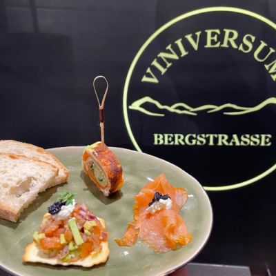 Teller mit Lachs Häppchen vor dem Viniversum Logo